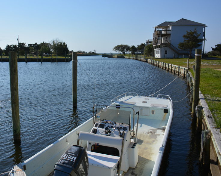 A boat sits docked next to a home in Frisco, NC
