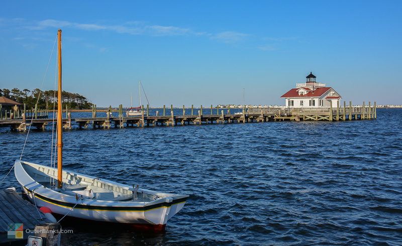 A small sailboat docked near the Roanoke Marshes Lighthouse