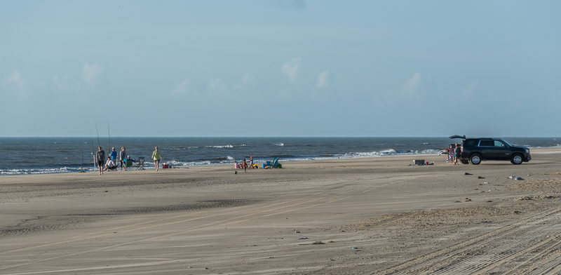 A family enjoys surf fishing and relaxing on a 4x4 beach