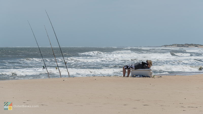 A surf fisherman lays on his cooler at Old Lighthouse Beach