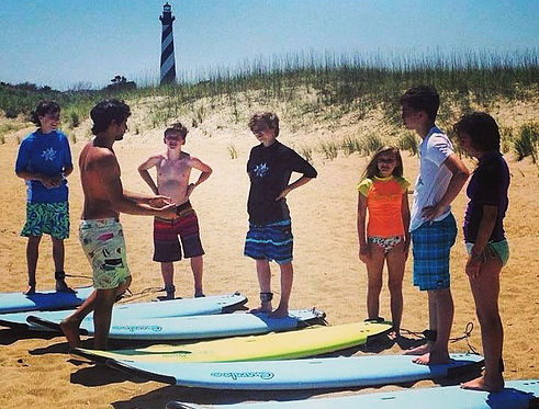 Hatteras Island Boardsports surf lesson on the beach in front of Cape Hatteras Lighthouse