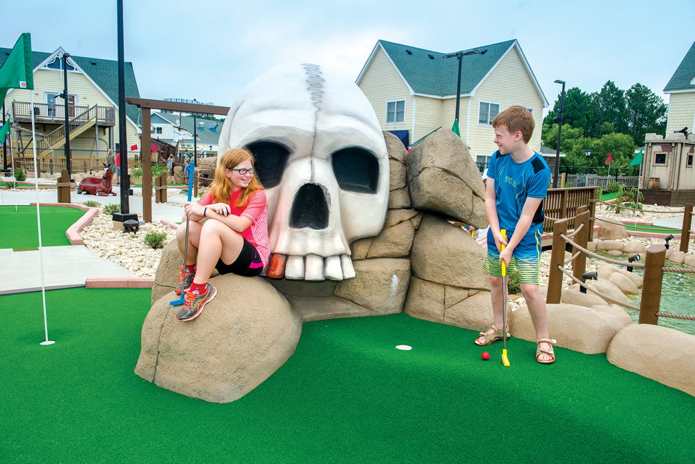 Kids play mini golf at Pirates Island at Corolla Light Town Center
