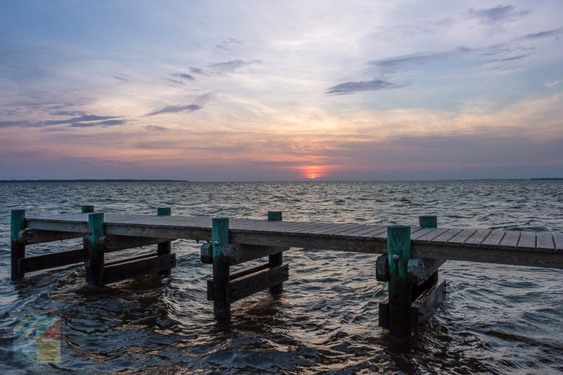 A soundside dock behind a Nags Head neighborhood at sunset